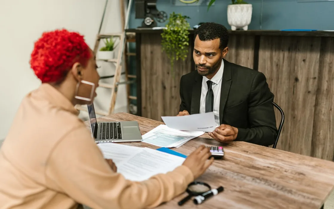 Accountant reviewing a client's papers across a desk
